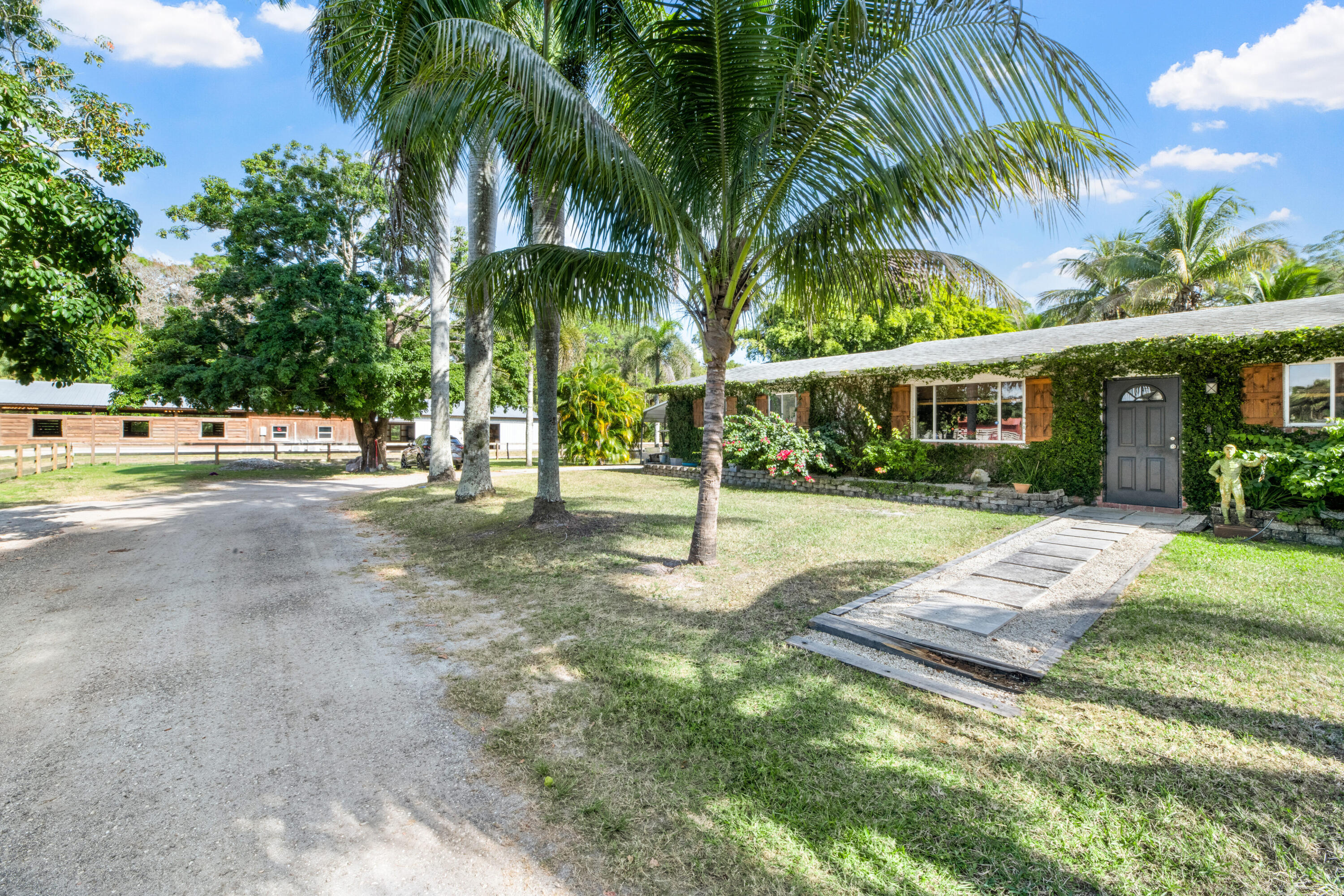 1068 D Road Loxahatchee, FL 33470 - Photo 15 of 73 a view of a house with a yard and palm trees