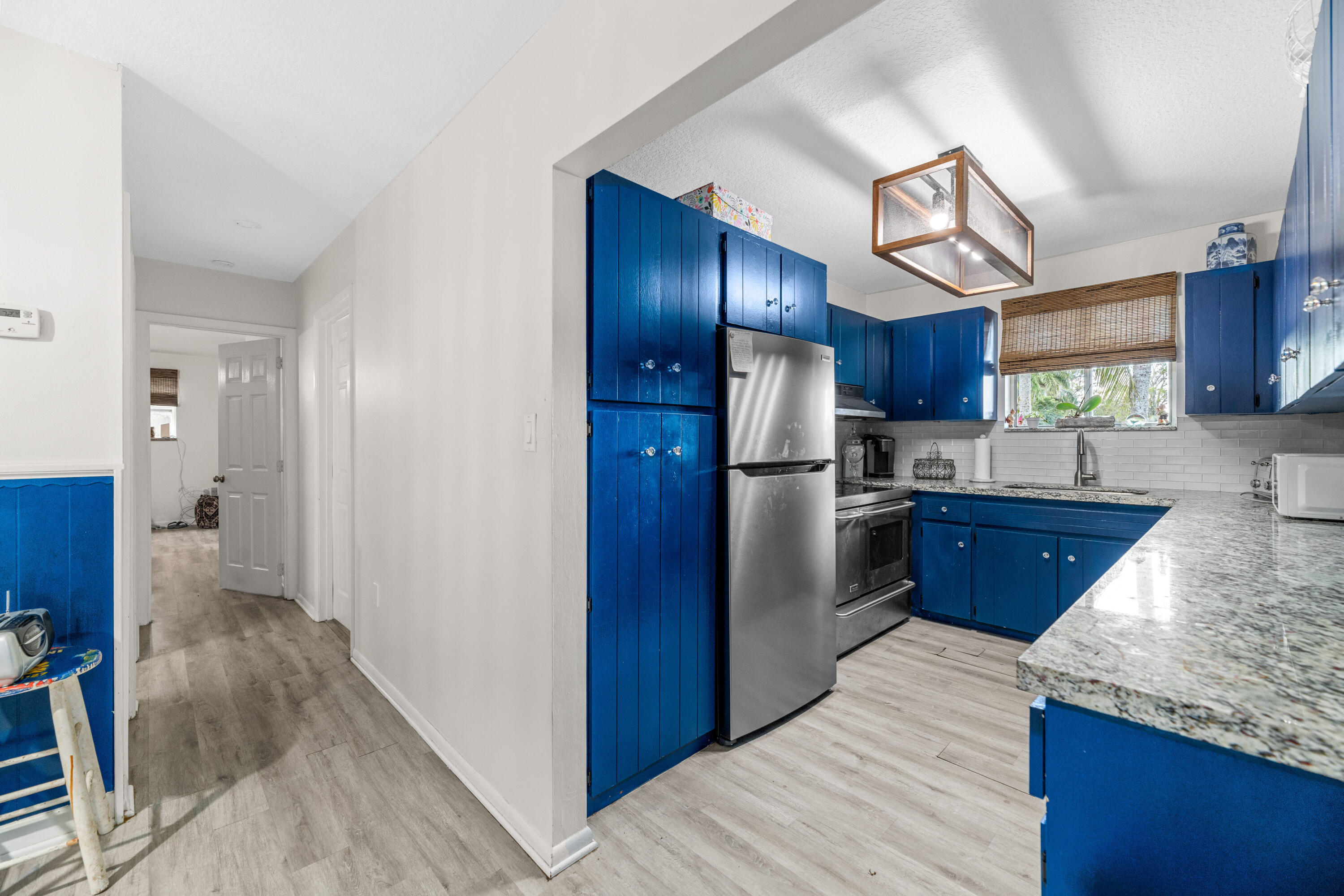 1068 D Road Loxahatchee, FL 33470 - Photo 63 of 73 a kitchen with stainless steel appliances granite countertop a refrigerator a sink dishwasher and wooden cabinets