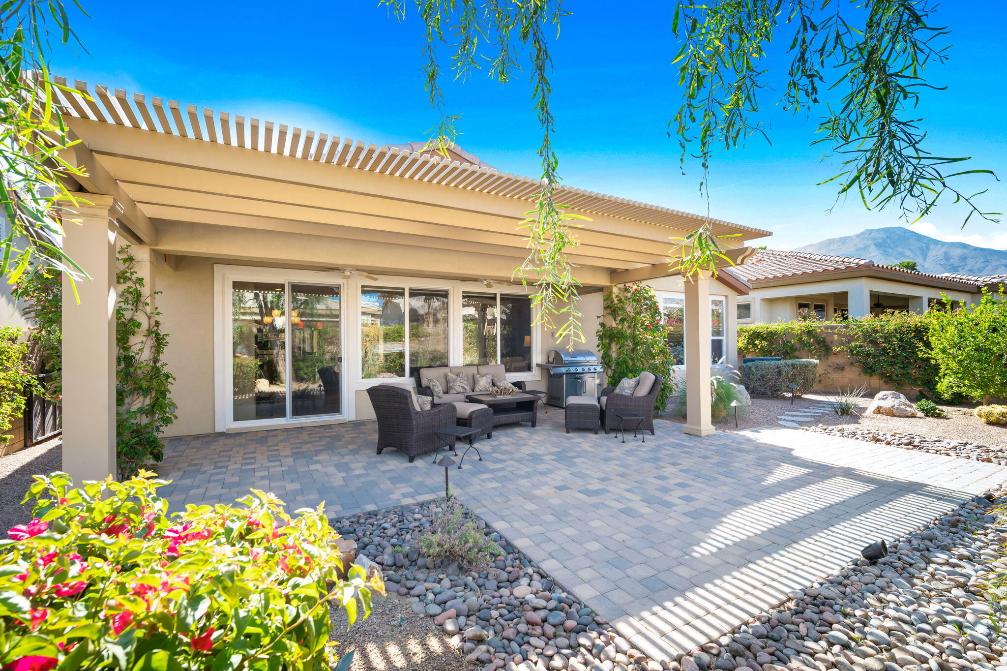 81820 Rustic Canyon Drive La Quinta, CA 92253 - Photo 32 of 85 a view of a patio with table and chairs potted plants and floor to ceiling window