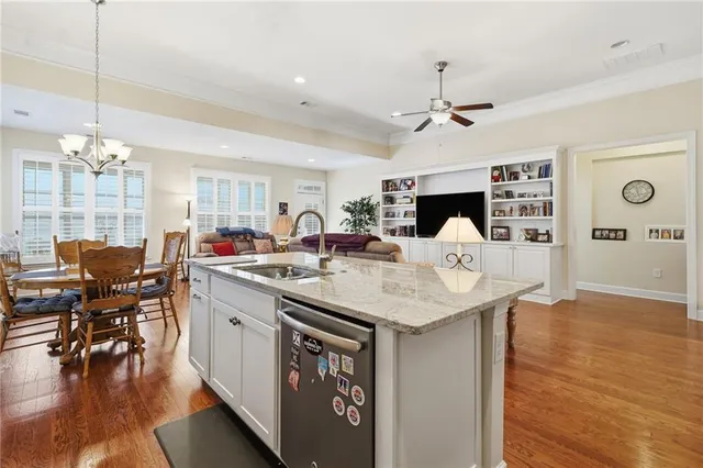 a kitchen with kitchen island granite countertop a table chairs sink and cabinets