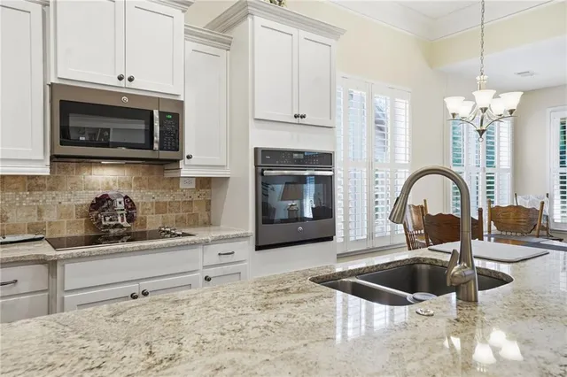a kitchen with stainless steel appliances granite countertop a sink and cabinets