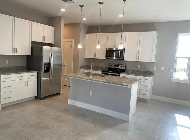 a kitchen with stainless steel appliances a refrigerator sink and cabinets
