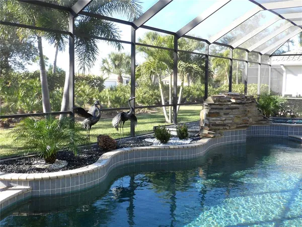 a view of a kitchen with kitchen island granite countertop a sink a stove and a chandelier