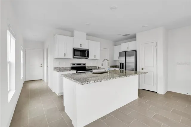 a kitchen with stainless steel appliances a sink stove refrigerator and cabinets