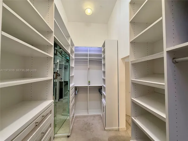 a view of walk in closet with empty racks