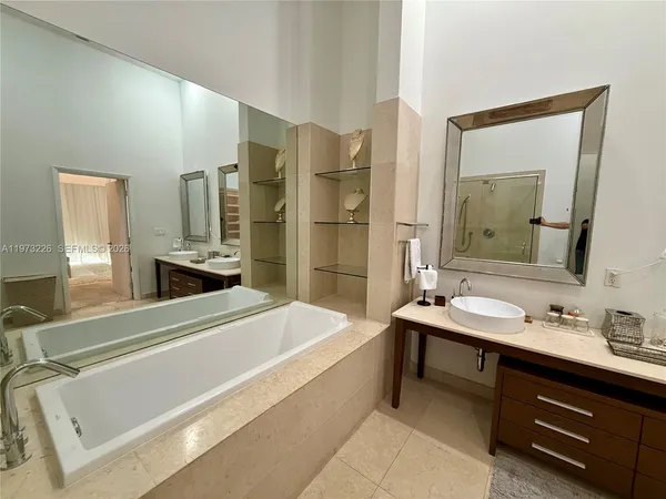 a bathroom with a tub sink and mirror