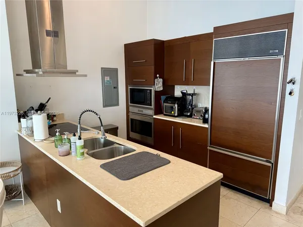 a kitchen with stainless steel appliances a refrigerator sink and microwave