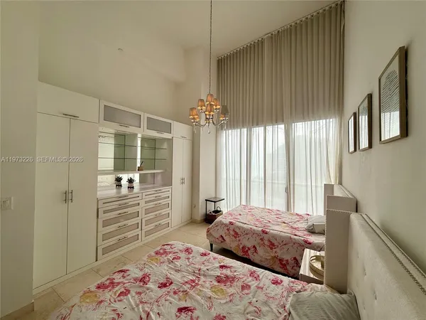 a bedroom with a bed and a chandelier