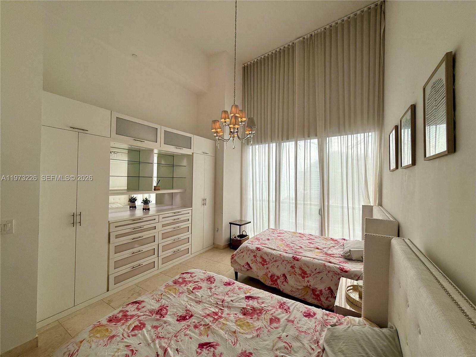 495 Brickell Avenue, Unit 1403 Miami, FL 33131 - Photo 29 of 48 a bedroom with a bed and a chandelier