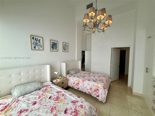 a bedroom with a bed and a chandelier