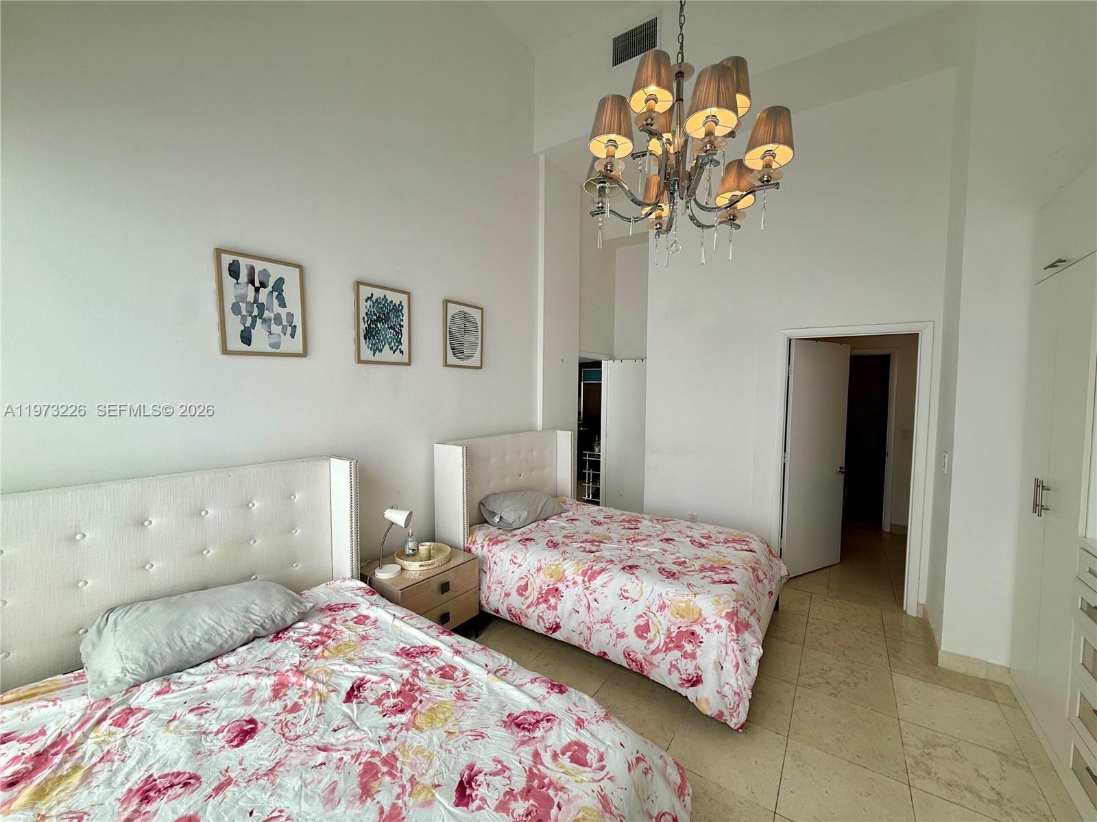 495 Brickell Avenue, Unit 1403 Miami, FL 33131 - Photo 31 of 48 a bedroom with a bed and a chandelier