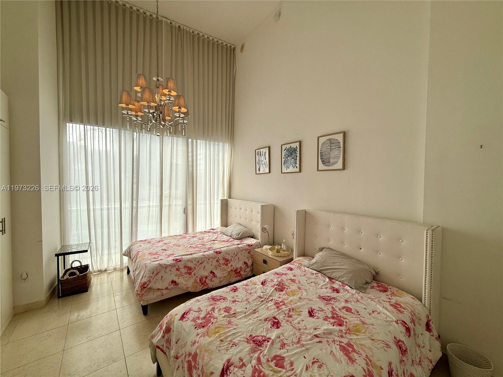 495 Brickell Avenue, Unit 1403 Miami, FL 33131 - Photo 32 of 48 a bedroom with two beds and a large window