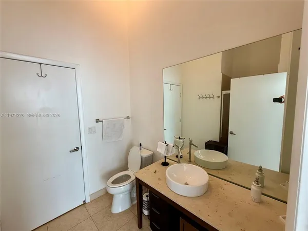 a bathroom with a granite countertop sink toilet a large mirror a shower and vanity