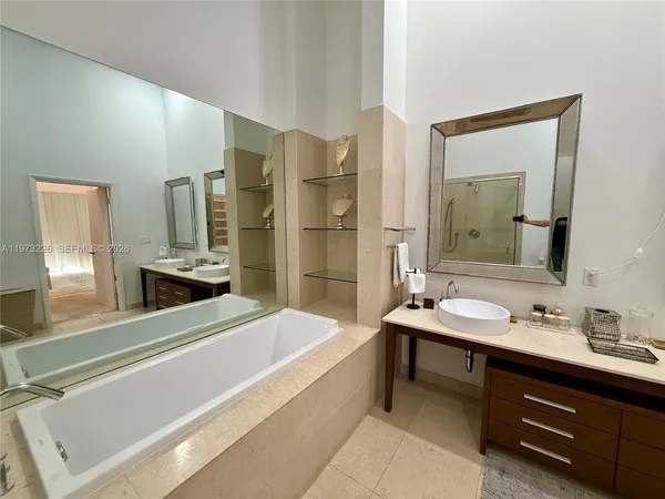 a spacious bathroom with a double vanity sink tub and a mirror