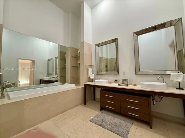 a bathroom with a tub sink and mirror