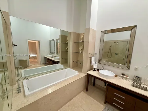 a bathroom with a tub sink and mirror