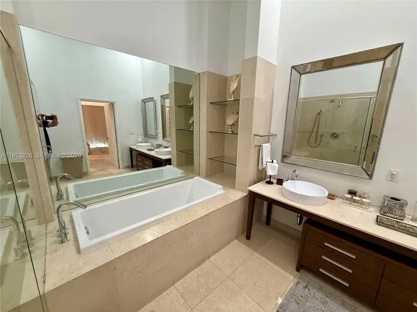 a bathroom with a tub sink and mirror