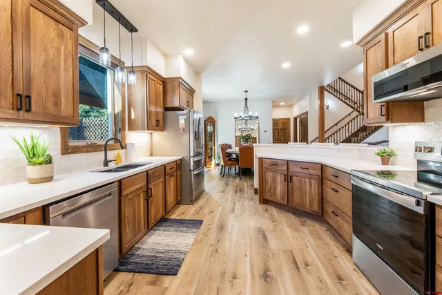 a large kitchen with stainless steel appliances lots of counter space and a sink