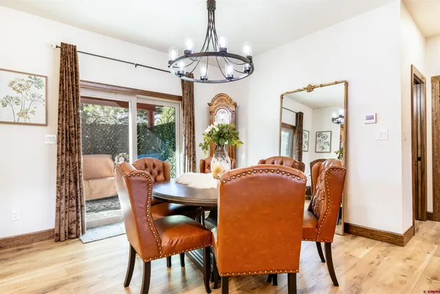 a dining room with furniture a chandelier and wooden floor