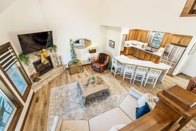 a living room with furniture a flat screen tv and floor to ceiling windows