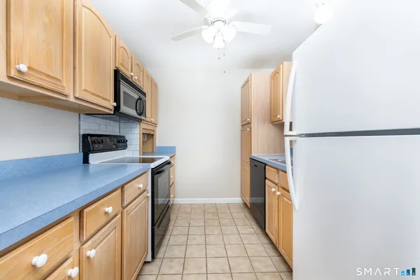 a kitchen with stainless steel appliances granite countertop a refrigerator a stove and a sink