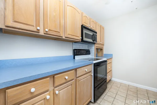 a kitchen with stainless steel appliances granite countertop a sink and dishwasher with white cabinets