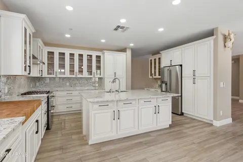 a large kitchen with stainless steel appliances granite countertop a stove and a refrigerator