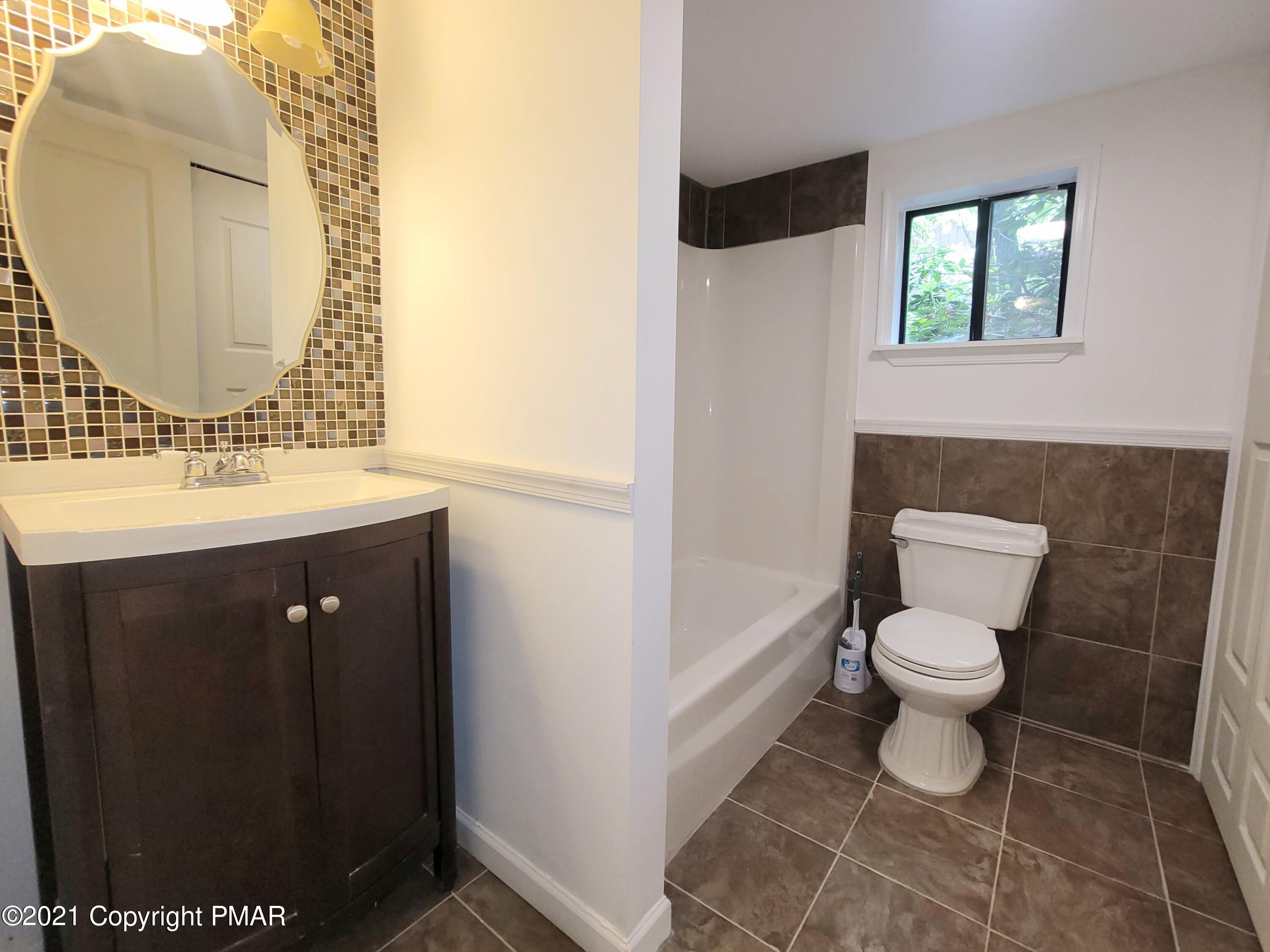 3153 Cherry Ridge Road Bushkill, PA 18324 - Photo 12 of 41 a bathroom with a toilet sink and mirror