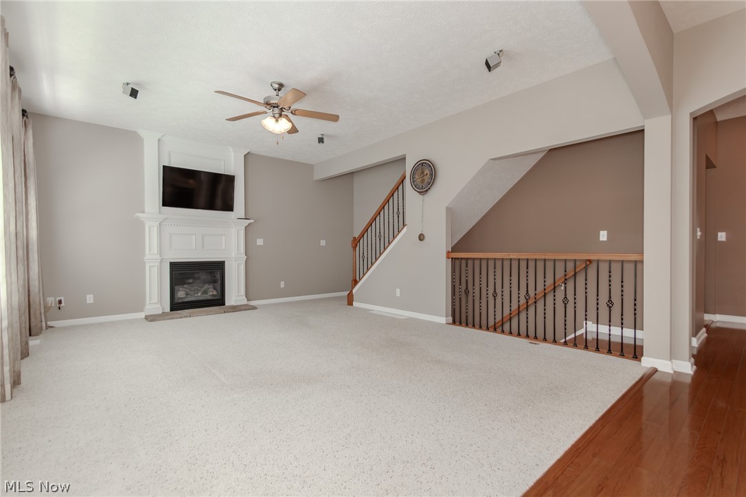 8375 Raleigh Place Painesville, OH 44077 - Photo 19 of 45 Great Room has Gas Fireplace, Ceiling Fans and shows entry to upper and lower levels