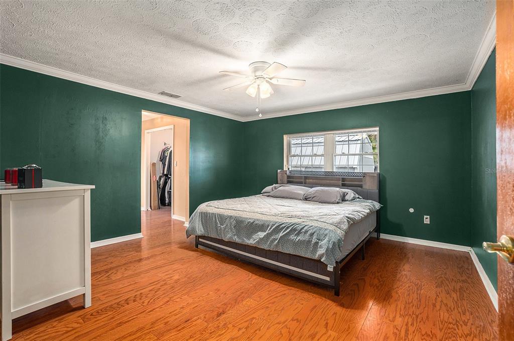 9738 Ray Street Hudson, FL 34669 - Photo 12 of 30 a spacious bedroom with a bed and a chandelier
