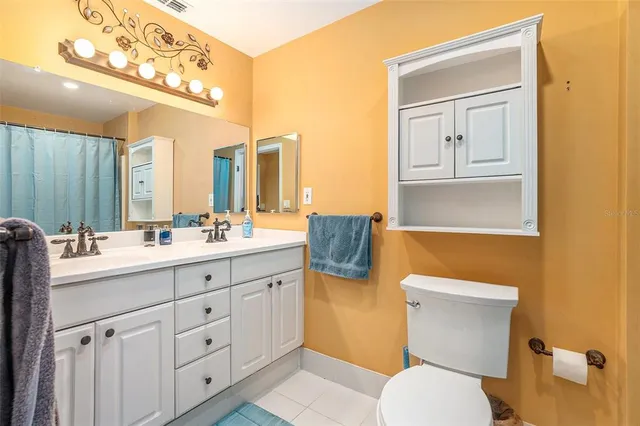 a bathroom with a toilet a sink a mirror a vanity and window