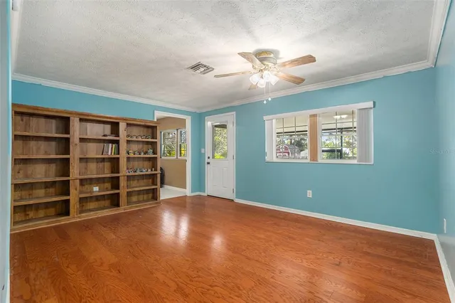 a view of an empty room with a bookshelf and a window