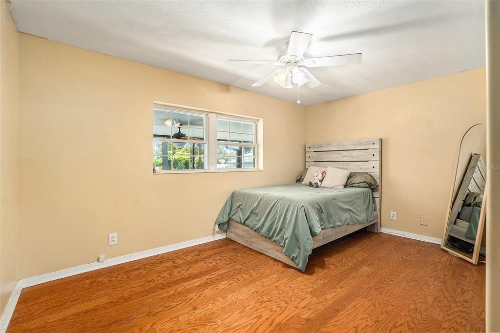 9738 Ray Street Hudson, FL 34669 - Photo 17 of 30 a bedroom with a bed and a chandelier