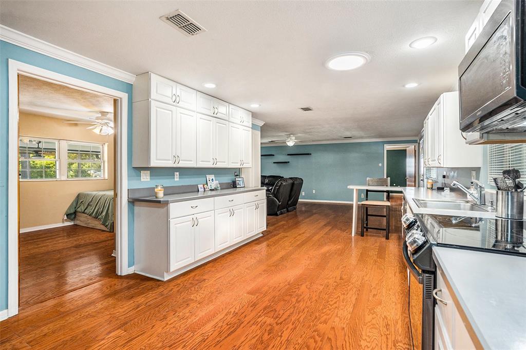 9738 Ray Street Hudson, FL 34669 - Photo 9 of 30 a kitchen with stainless steel appliances granite countertop sink stove top oven and cabinets