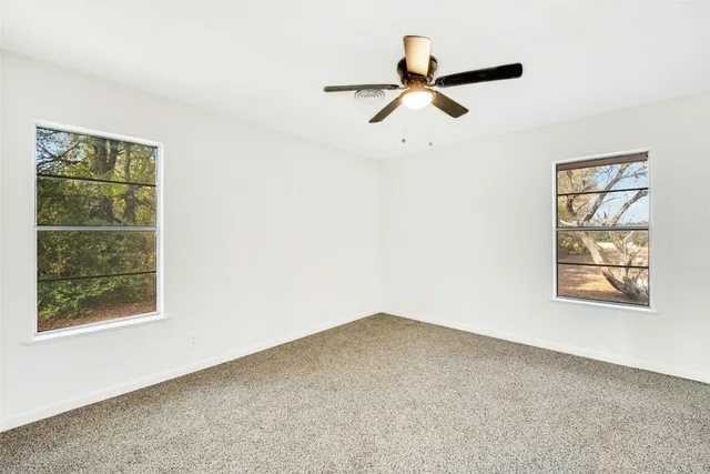 a view of a room with a window and a ceiling fan
