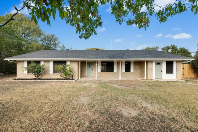 front view of a house with a house yard and a garage