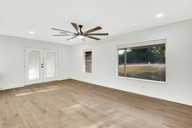 a view of an empty room with a window and a kitchen