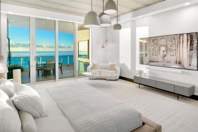 a spacious bedroom with a bed and glass walk in closet