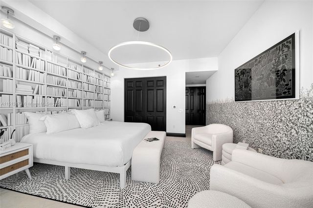 a living room with a couch and a large mirror with wooden floor