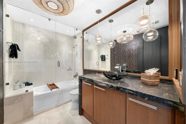 a bathroom with a granite countertop sink a large mirror and a bathtub