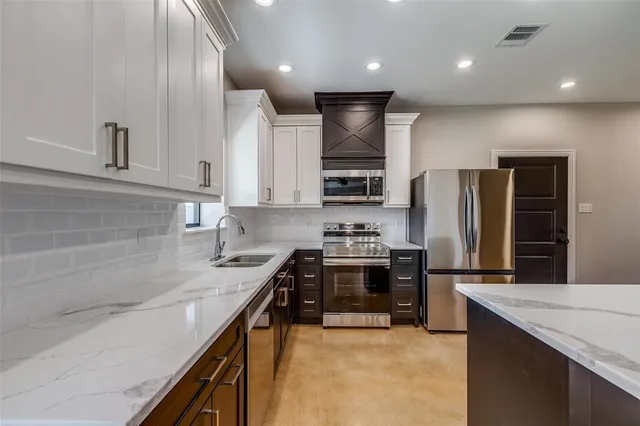 a kitchen with stainless steel appliances granite countertop a sink stove and refrigerator
