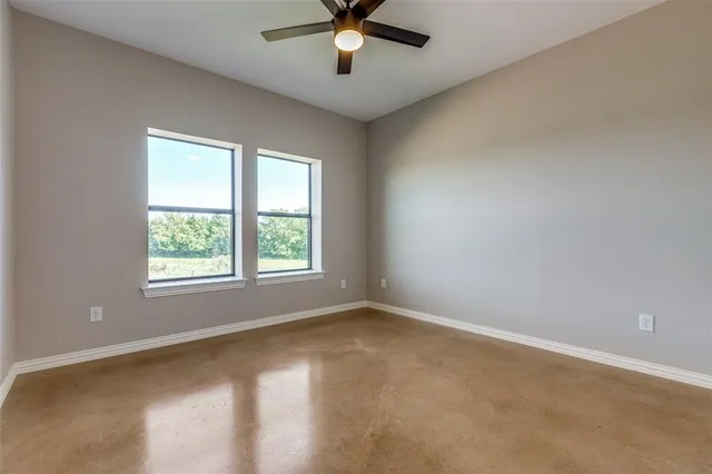 an empty room with a window and a fan