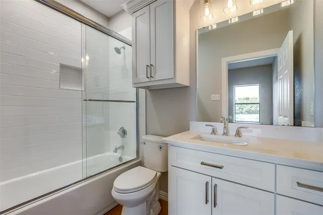 a bathroom with a sink a toilet and a large mirror
