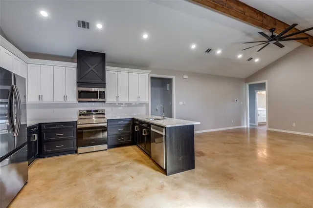 a kitchen with stainless steel appliances granite countertop a stove and a refrigerator