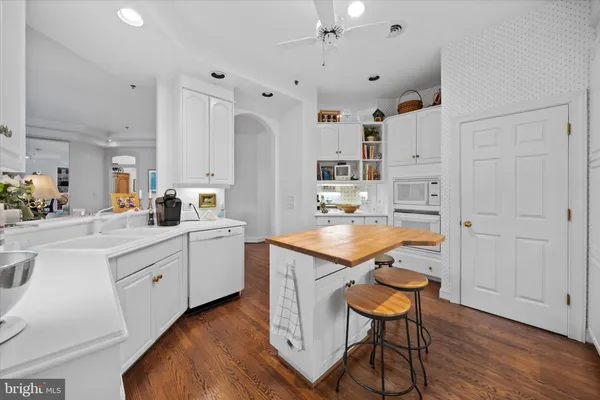 a kitchen with granite countertop a sink cabinets and wooden floor