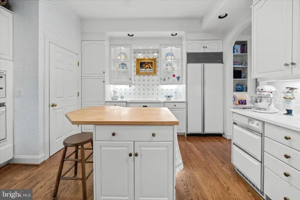 a kitchen with stainless steel appliances a sink cabinets and wooden floor