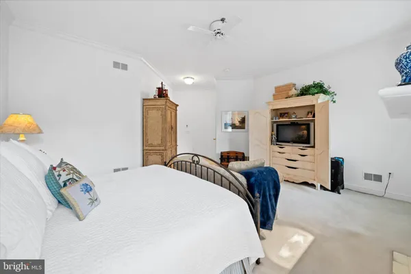 a bedroom with a bed a flat screen tv and dresser