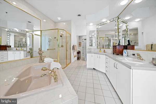 a large white bathroom with a double vanity sink mirror and shower