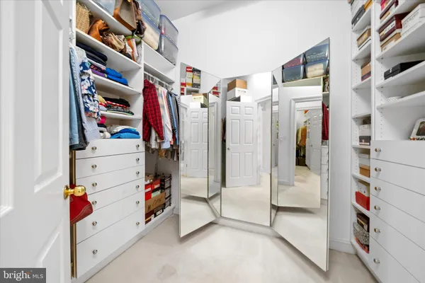 a view of walk in closet with clothes and shoes