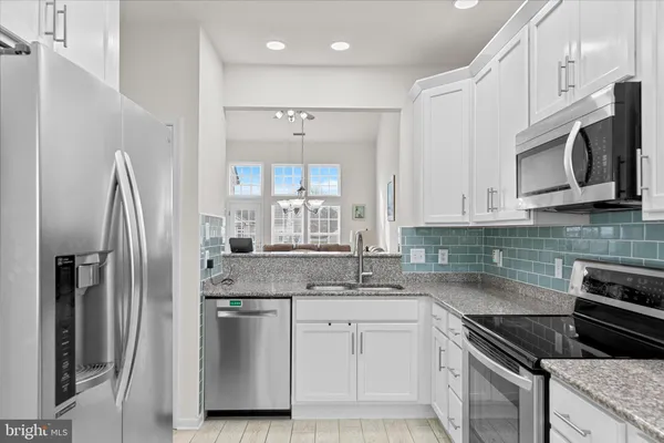 a kitchen with stainless steel appliances granite countertop a refrigerator sink and microwave